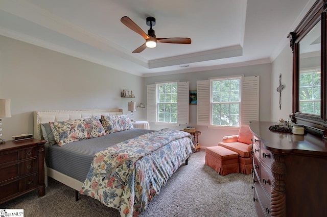 bedroom with carpet, a tray ceiling, a ceiling fan, and ornamental molding