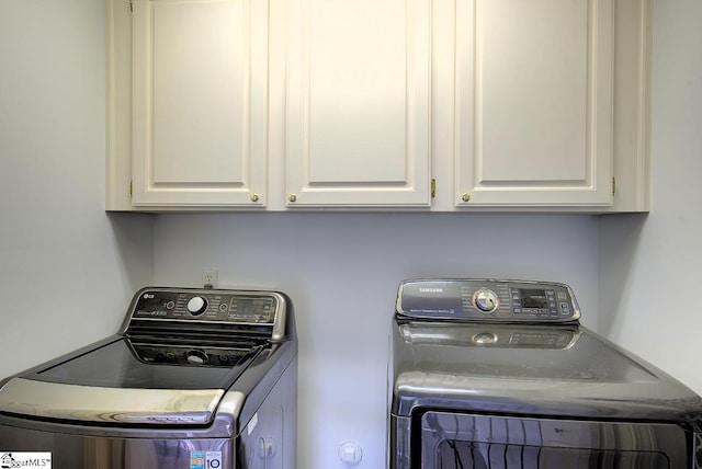 washroom featuring separate washer and dryer and cabinet space