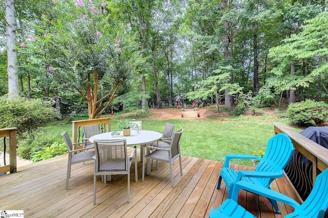 wooden deck with outdoor dining area and a lawn