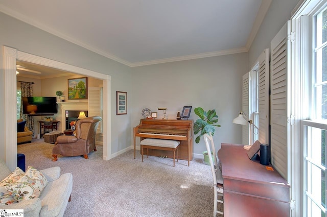 sitting room with baseboards, crown molding, a fireplace, and light colored carpet