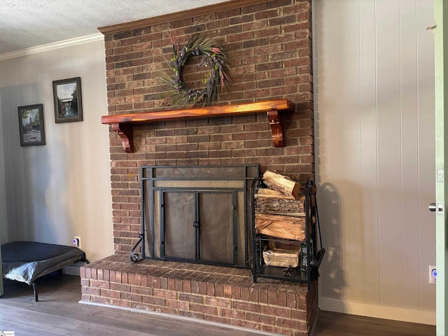 room details featuring a textured ceiling, wood finished floors, baseboards, a brick fireplace, and crown molding