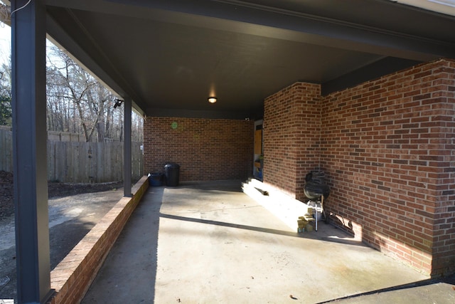 view of patio with a carport and fence