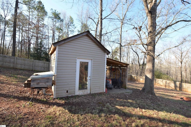 view of outbuilding with a fenced backyard and an outbuilding