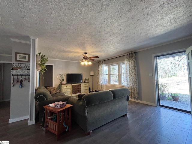 living room featuring a textured ceiling, ornamental molding, dark wood-style flooring, and baseboards