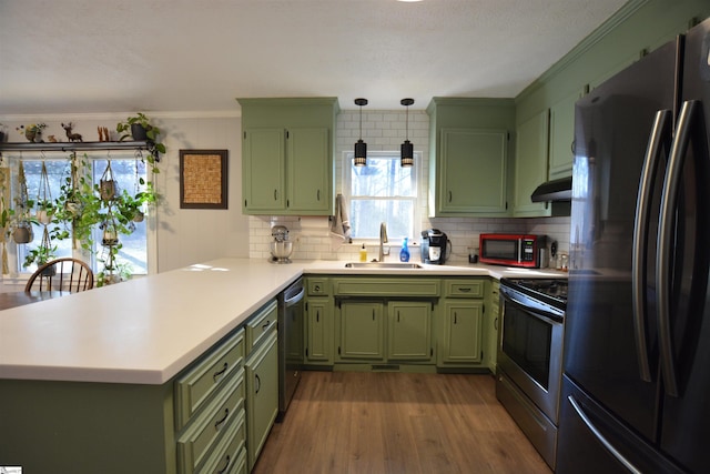 kitchen featuring a sink, stainless steel appliances, light countertops, and green cabinetry