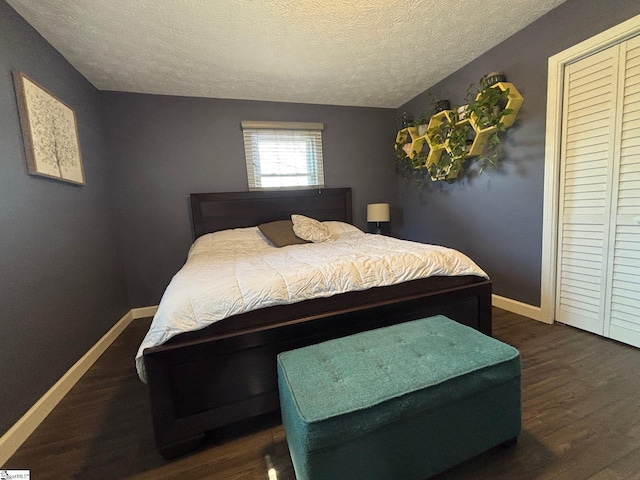 bedroom with baseboards, dark wood finished floors, and a textured ceiling