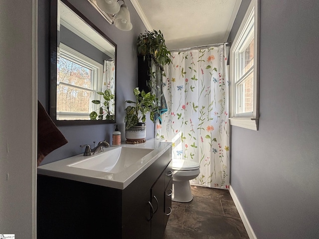 bathroom with vanity, toilet, and baseboards