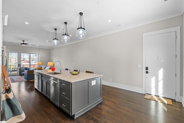 kitchen featuring decorative light fixtures, gray cabinetry, open floor plan, a sink, and an island with sink