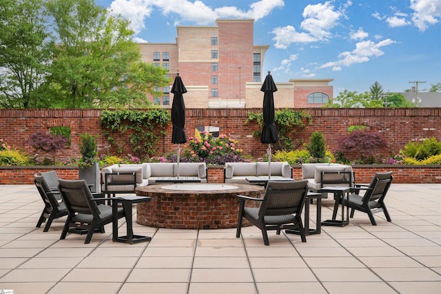 view of patio with an outdoor living space with a fire pit