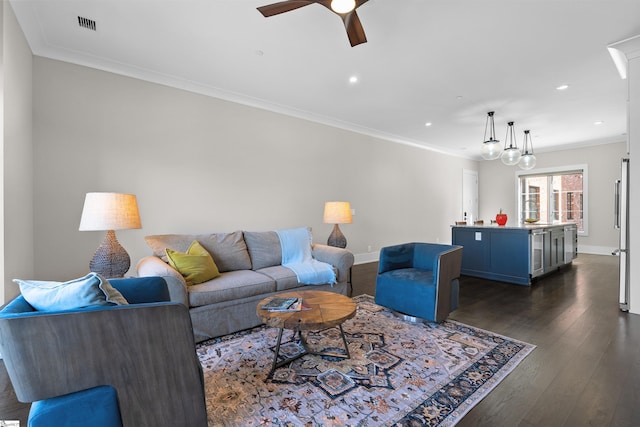 living room with dark wood-style floors, ornamental molding, and baseboards