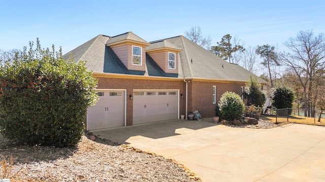 view of front of property featuring concrete driveway, brick siding, an attached garage, and fence