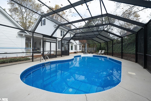 pool with glass enclosure and a patio area