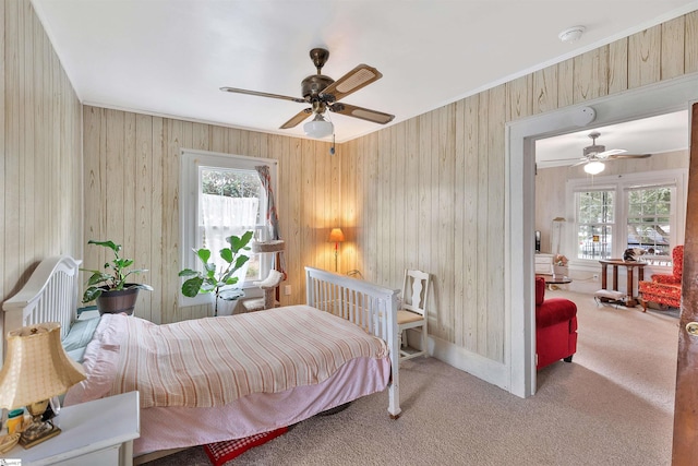 bedroom featuring ornamental molding, carpet flooring, baseboards, and a ceiling fan