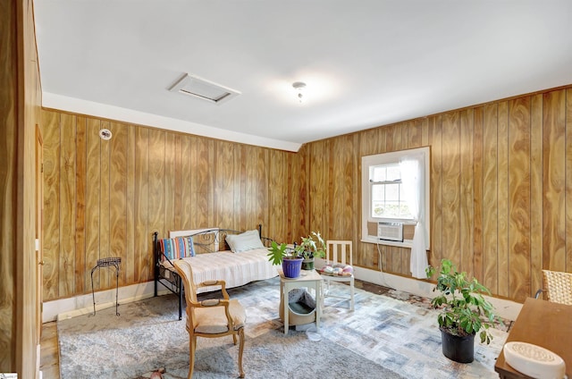 living area with attic access, cooling unit, and wooden walls