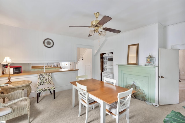 dining room with ceiling fan and light colored carpet