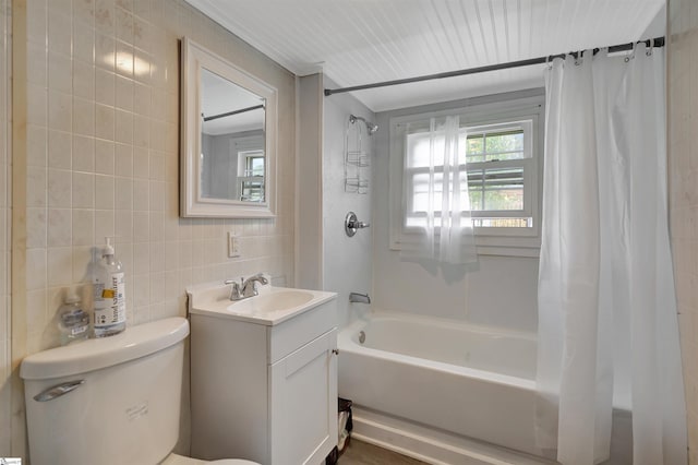 bathroom with toilet, vanity, tile walls, and shower / tub combo with curtain