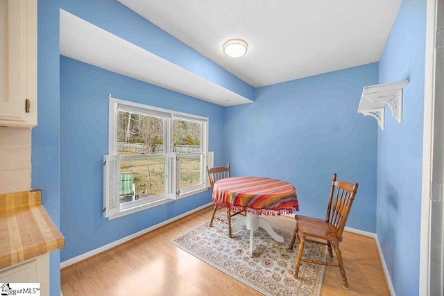 dining area featuring light wood-type flooring and baseboards