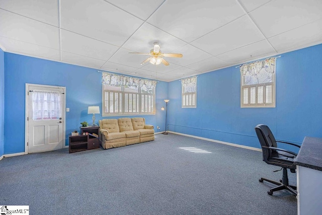 unfurnished office with carpet floors, baseboards, a ceiling fan, and a wealth of natural light