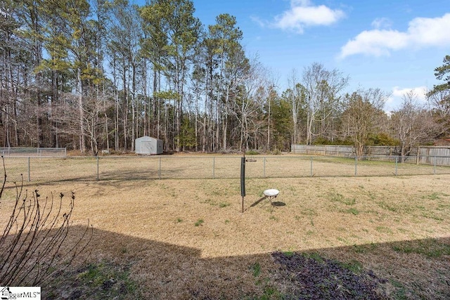 view of yard featuring a storage shed, an outdoor structure, and a fenced backyard