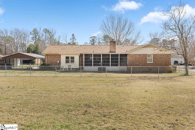 rear view of house featuring a sunroom, a chimney, a lawn, and brick siding