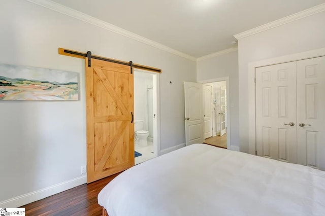 bedroom with crown molding, a closet, a barn door, dark wood-type flooring, and baseboards