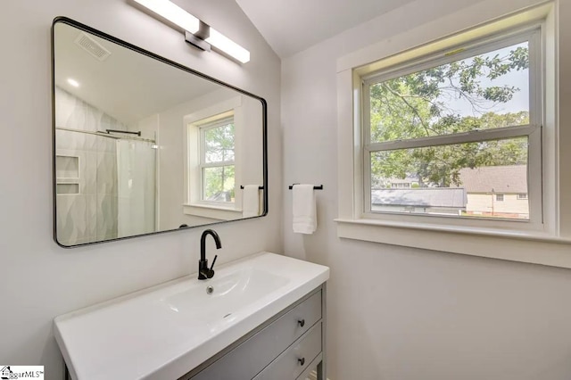bathroom with curtained shower, visible vents, vaulted ceiling, and vanity