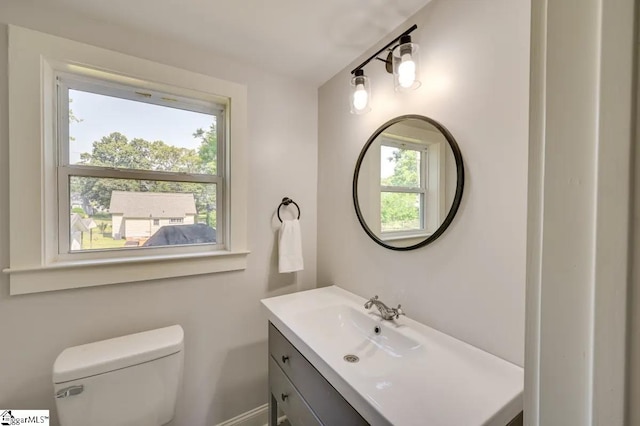 bathroom with toilet, plenty of natural light, and vanity