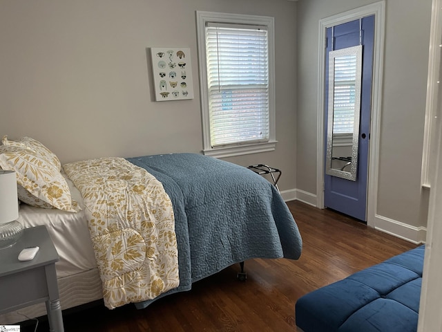 bedroom featuring baseboards and dark wood-style flooring