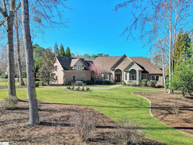 french country inspired facade with a front yard