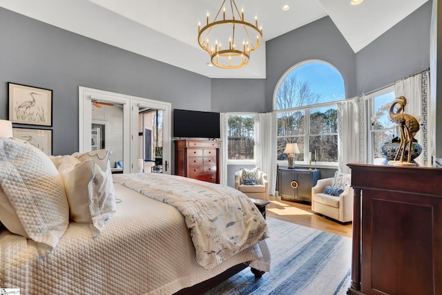 bedroom featuring a chandelier, high vaulted ceiling, light wood finished floors, and recessed lighting