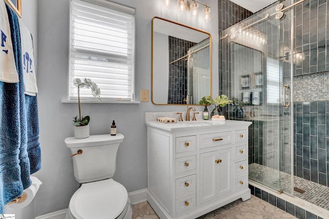 bathroom featuring toilet, a shower stall, and vanity