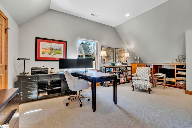 office featuring visible vents, vaulted ceiling, and light carpet