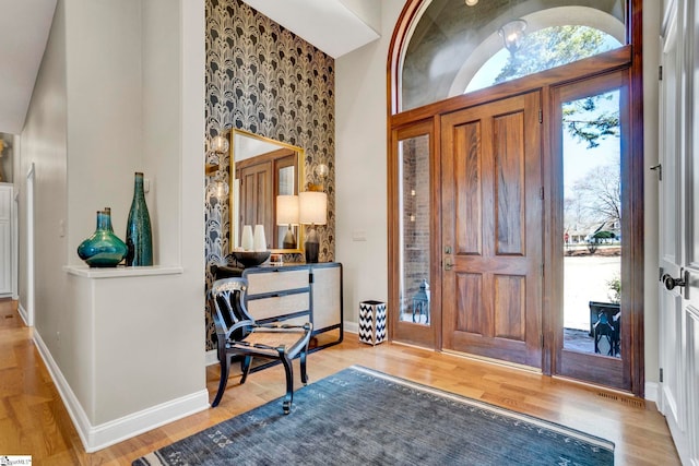 entryway featuring light wood-type flooring, plenty of natural light, and baseboards