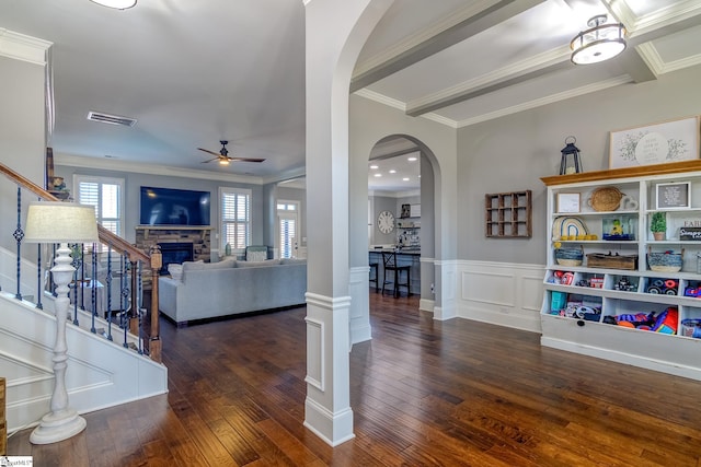 living room with visible vents, arched walkways, dark wood-style floors, stairway, and a fireplace