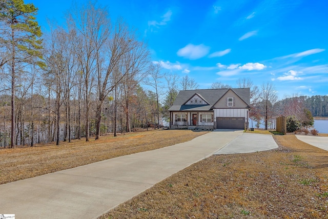 view of front of property featuring a porch, concrete driveway, board and batten siding, and a front lawn