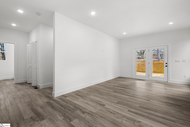 unfurnished room featuring a wealth of natural light, recessed lighting, and wood finished floors