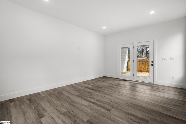 empty room with dark wood-type flooring, recessed lighting, visible vents, and baseboards