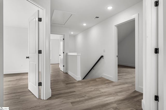 corridor featuring recessed lighting, light wood-style flooring, attic access, an upstairs landing, and baseboards