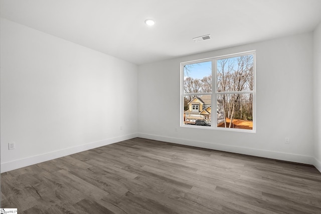 empty room featuring recessed lighting, visible vents, baseboards, and wood finished floors