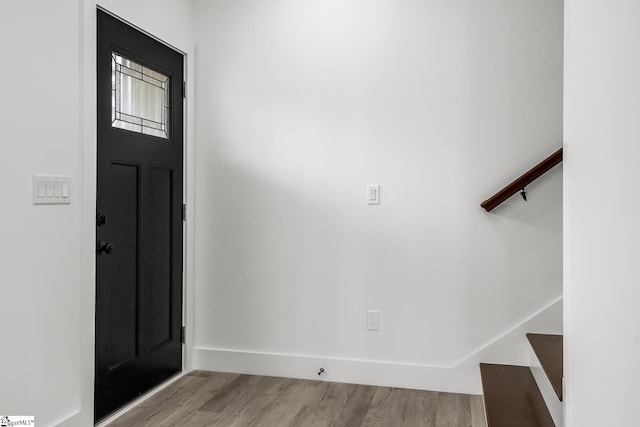 entryway with stairs, light wood-style flooring, and baseboards