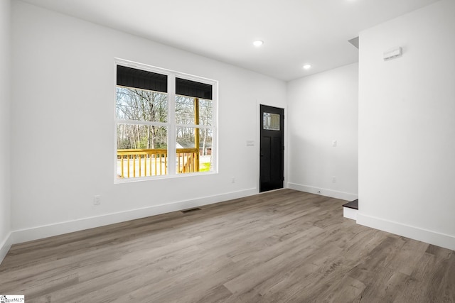 unfurnished room featuring light wood-style floors, visible vents, baseboards, and recessed lighting