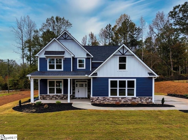 craftsman inspired home with stone siding, a porch, board and batten siding, and a front yard