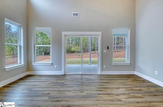 interior space with light wood-type flooring, visible vents, and baseboards