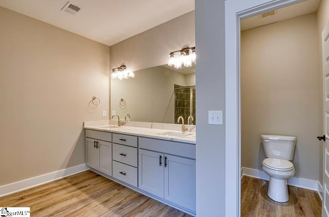 full bath featuring visible vents, a sink, baseboards, and wood finished floors