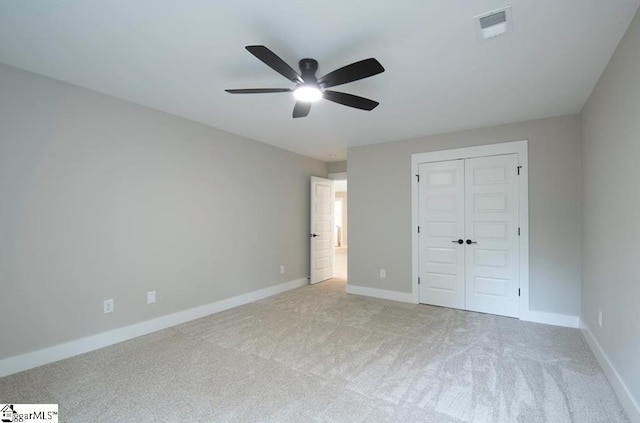 unfurnished bedroom with light colored carpet, a closet, visible vents, and baseboards