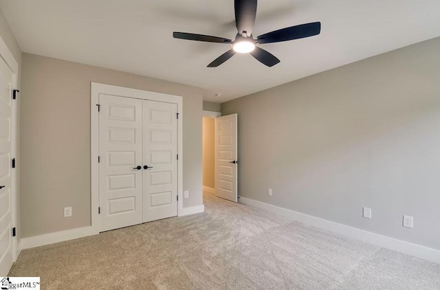 unfurnished bedroom with light carpet, a ceiling fan, baseboards, and a closet