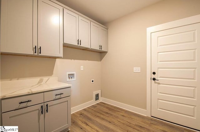 washroom with washer hookup, cabinet space, light wood-style floors, electric dryer hookup, and baseboards