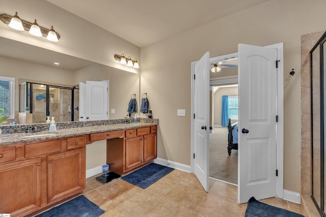 ensuite bathroom featuring double vanity, ensuite bathroom, a stall shower, a sink, and tile patterned flooring