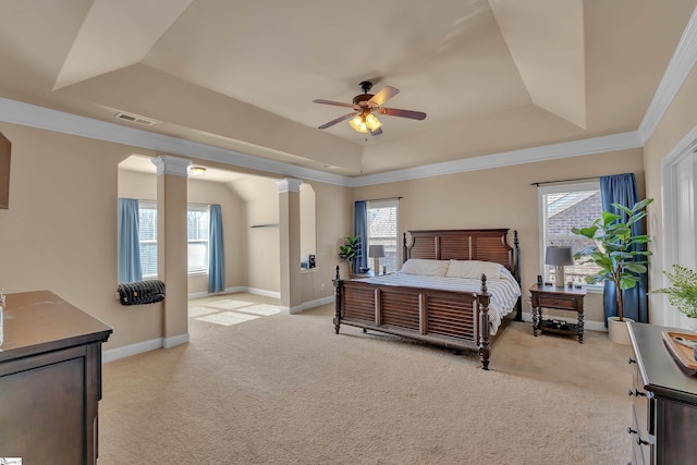 bedroom featuring light carpet, visible vents, baseboards, a tray ceiling, and decorative columns