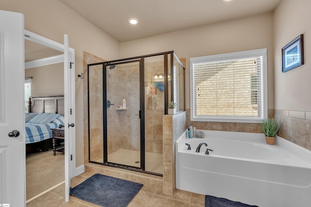 bathroom featuring ensuite bathroom, plenty of natural light, tile patterned flooring, and a shower stall